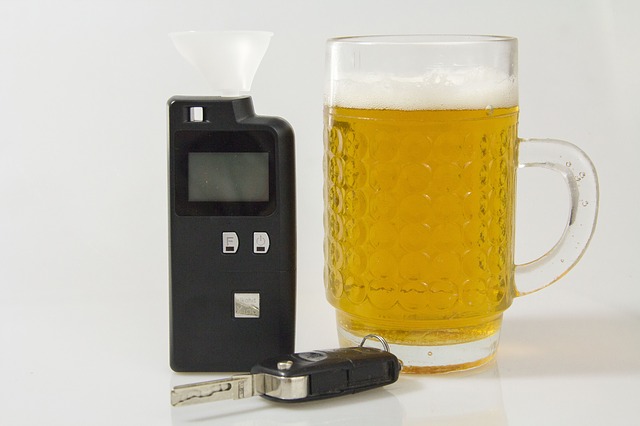 alkoholtestr, klíčky od auta a pivo